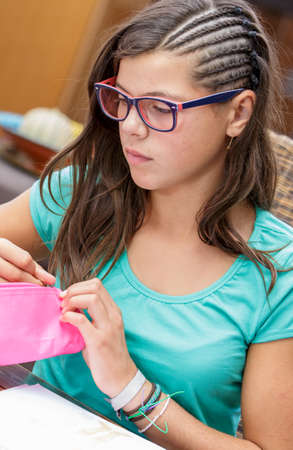 closeup of a pretty student girl doing homework at homeの写真素材
