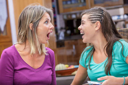 mother and daughter sharing a moment of complicity and laughingの写真素材