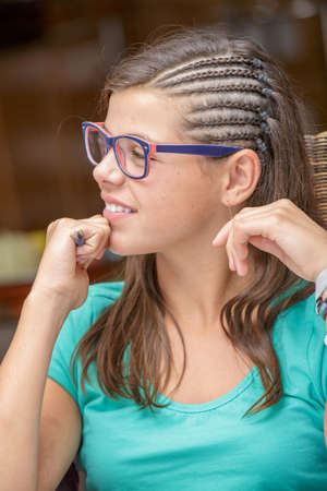 Side view portrait of beautiful smiling girl wearing glasses with long brown hairの写真素材