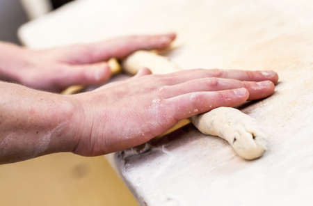 Close-up the hand of a baker kneading and shaping dough