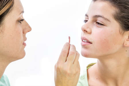 pretty young woman  applying make-up a girl smiling