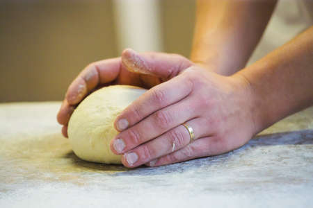 Close-up the hand of a baker kneading and shaping dough
