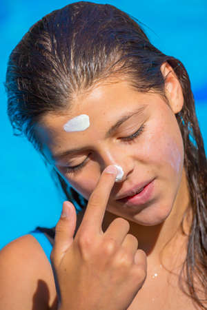 Protect sunscreen applied to the face of cute young girlの写真素材