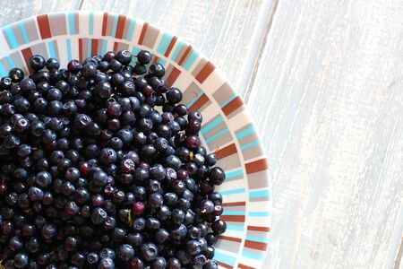 Bilberries in white plate on wooden grey desk. Stock photo.の写真素材