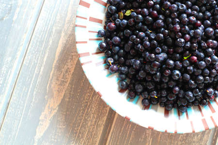 Bilberries in white plate on wooden grey desk. Stock photo.の写真素材
