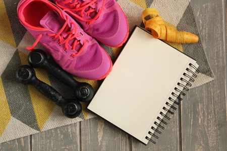 Trainers, dumbbells, ribbon, mat on floor.の写真素材