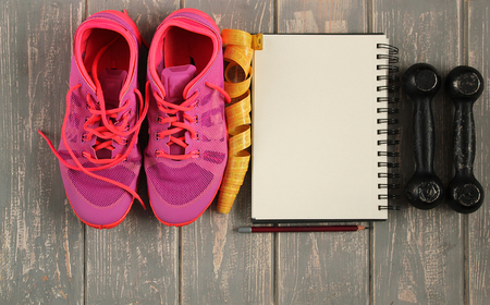 Trainers, dumbbells, ribbon, mat on floor.の写真素材