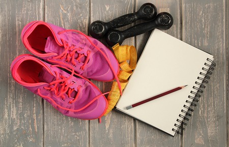 Trainers, dumbbells, ribbon, mat on floor.の写真素材