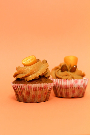 Cream caramel cupcake on orange background decorated by almondsの写真素材