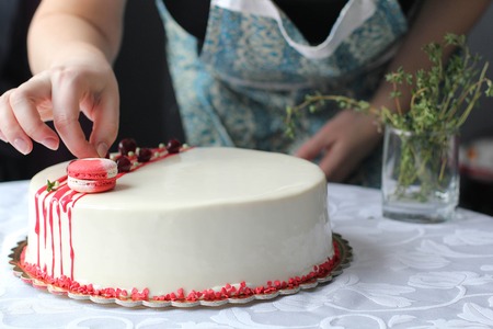 Tasty white homemade cake decorated by red berries and macaronの写真素材