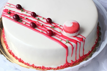Tasty white homemade cake decorated by red berries and macaronの写真素材