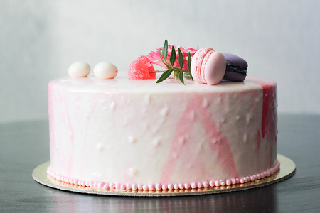 Tasty pink homemade cake decorated by rose and macarons. Marbelous effect on cakeの写真素材