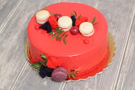 Tasty red homemade cake decorated by red candies and macaronsの写真素材