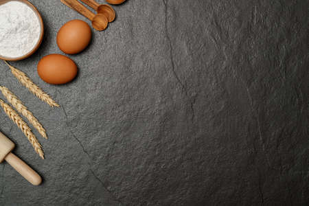 Top view black table with eggs, flour and utensils. Copy space for textの写真素材