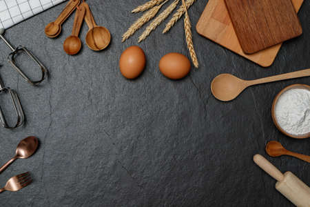 Top view black table with eggs, flour and utensils. Copy space for textの写真素材