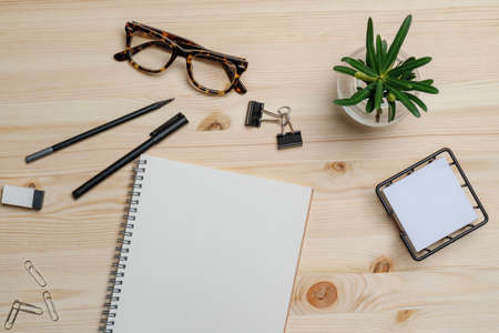 Top view workspace mockup on wood table with notebook, pen, glasses, clips and accessories.の写真素材