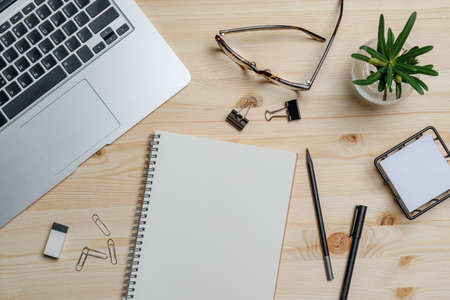 Top view workspace mockup on wood desk with notebook, pen, glasses, clips and accessories.の写真素材