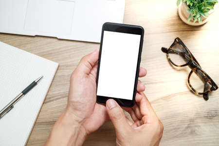 man using smartphone on wood desk work.の写真素材