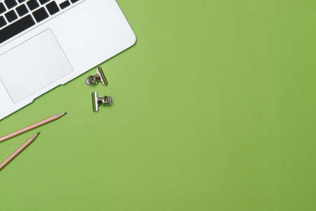 Workspace home office on green desk with laptop. Top view with copy space, flat lay.の写真素材