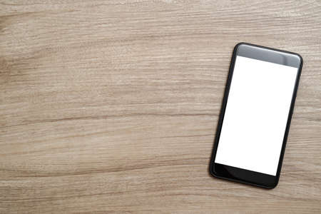Top view with smartphone on wooden desk. Copy space for text.