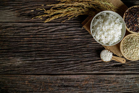 Brown rice in bowl on wooden desk with spike rice. Free space for your text.の写真素材