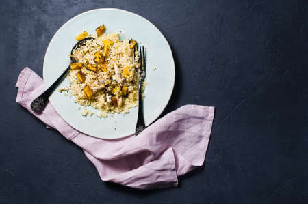 Salad of baked pumpkin, quinoa and chicken. Dark background, top view, space for text