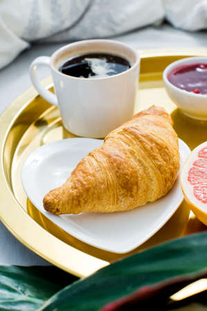 Classic Breakfast in bed, hotel service. Coffee, jam, croissant, orange juice, grapefruit, lychee....