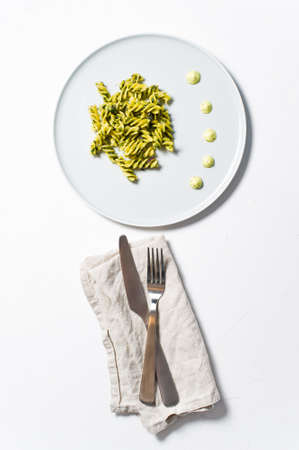 Gluten-free pasta with spinach. Diet dish. Minimalism. White background, top view