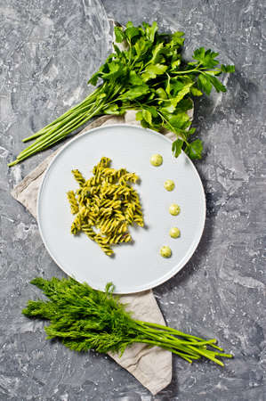 Gluten-free pasta with spinach. Vegetarian food. Gray background, top view, space for text