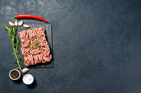 Raw pork minced on a stone Board. Black background, top view, space for text