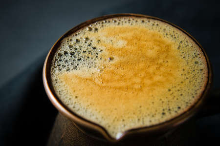 coffee froth in Turk. Black background, top view, close upの写真素材