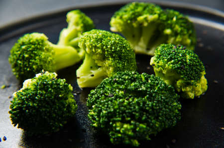 Broccoli on a black plate. Black background, side view, close-upの写真素材