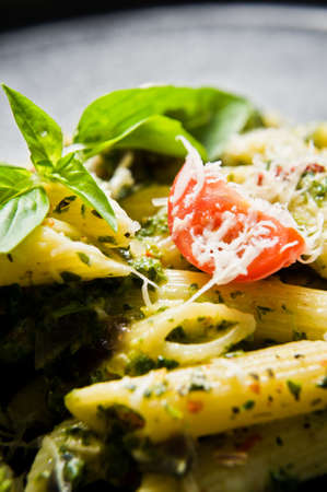 Italian pasta Penne with spinach, cherry tomatoes and Basil. Black background, top view, close upの写真素材