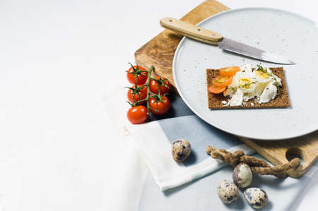 Quail egg toast. Ingredients tomatoes, egg, cheese, rye bread. White background, side viewの写真素材