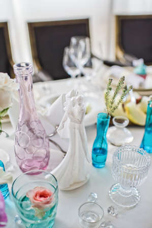 Ceramic figurines of the newlyweds on the table in the restaurant, wedding