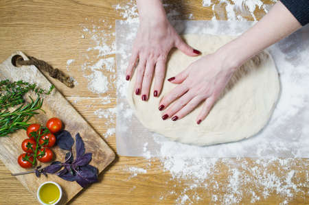 The chef prepares Focaccia. Ingredients for Focaccia: dough, tomatoes, rosemary, thyme, Basil, olive...
