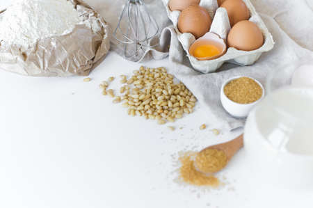 Ingredients for homemade baking. Eggs, milk, flour, sugar. White background, side view