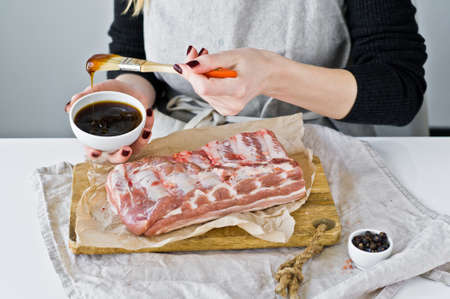 The chef prepares pork ribs barbecue. Gray background, top view, space for textの写真素材