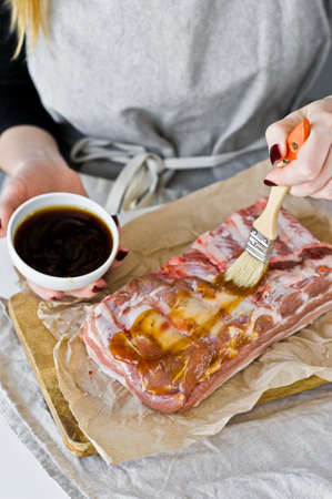 The chef prepares pork ribs barbecue. Gray background, top view, space for textの写真素材