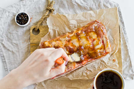 The chef prepares pork ribs barbecue. Gray background, top view, space for textの写真素材