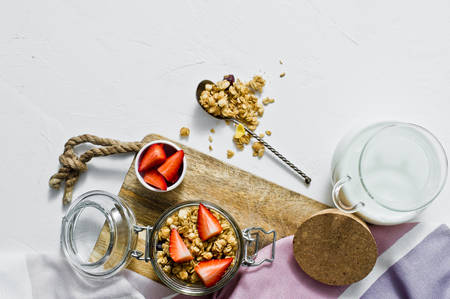 Muesli with strawberries in a glass jar. White background, top view. Healthy vegan snackの写真素材