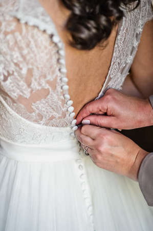 Mom's hands tie the bride's dressの写真素材