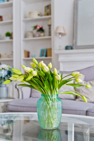 Vase with yellow tulips on the table in the room. Stylish interior backgroundの写真素材