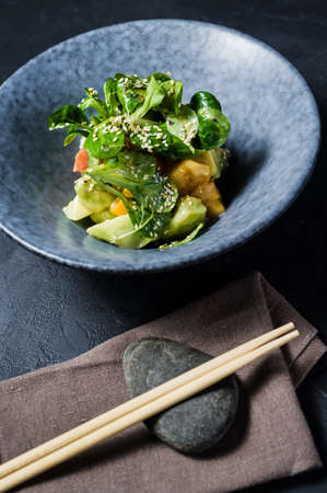 Mango salad, avocado, lettuce, dark background, top viewの写真素材