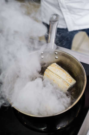 Chef prepares halibut under celery in the restaurant kitchenの写真素材