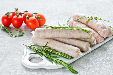 Assorted sausages on the cutting Board, pork, beef, chicken, Turkey. Gray background, side viewの写真素材