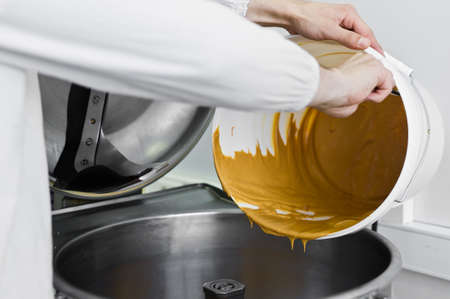 worker fills peanut butter in industrial mixer, food industry, conveyor line