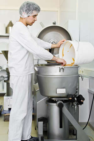 30.03.2019 Russia, St. Petersburg - worker fills peanut butter in industrial mixer, food industry, conveyor lineのeditorial素材
