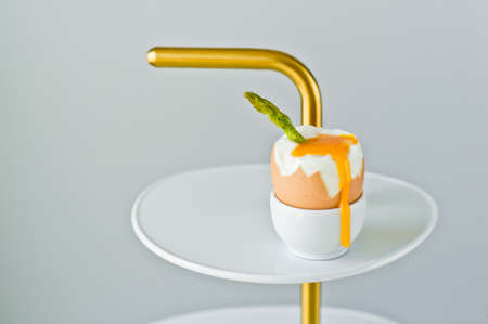 Peeled boiled egg with asparagus. Side view, gray background, space for textの写真素材