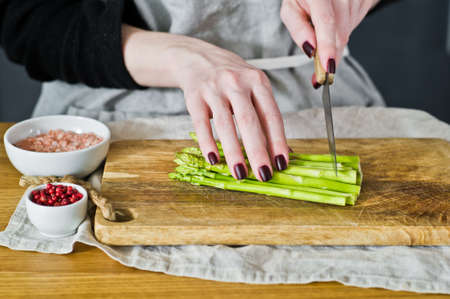 The chef cut mini asparagus.Side view, kitchen background, concept of cooking asparagus in bacon.の写真素材